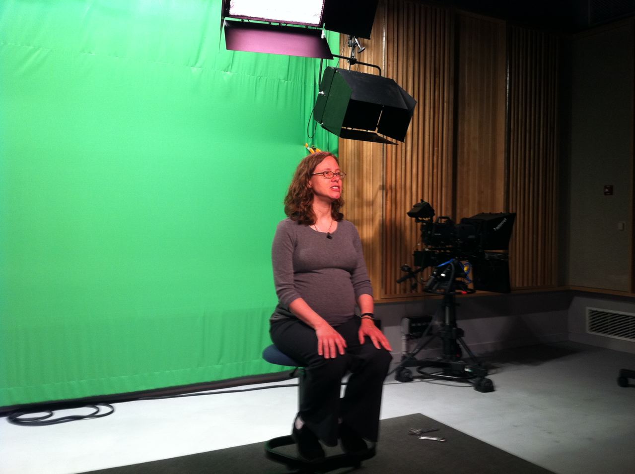 Science Librarian, Jennifer King, sitting in front of a green screen