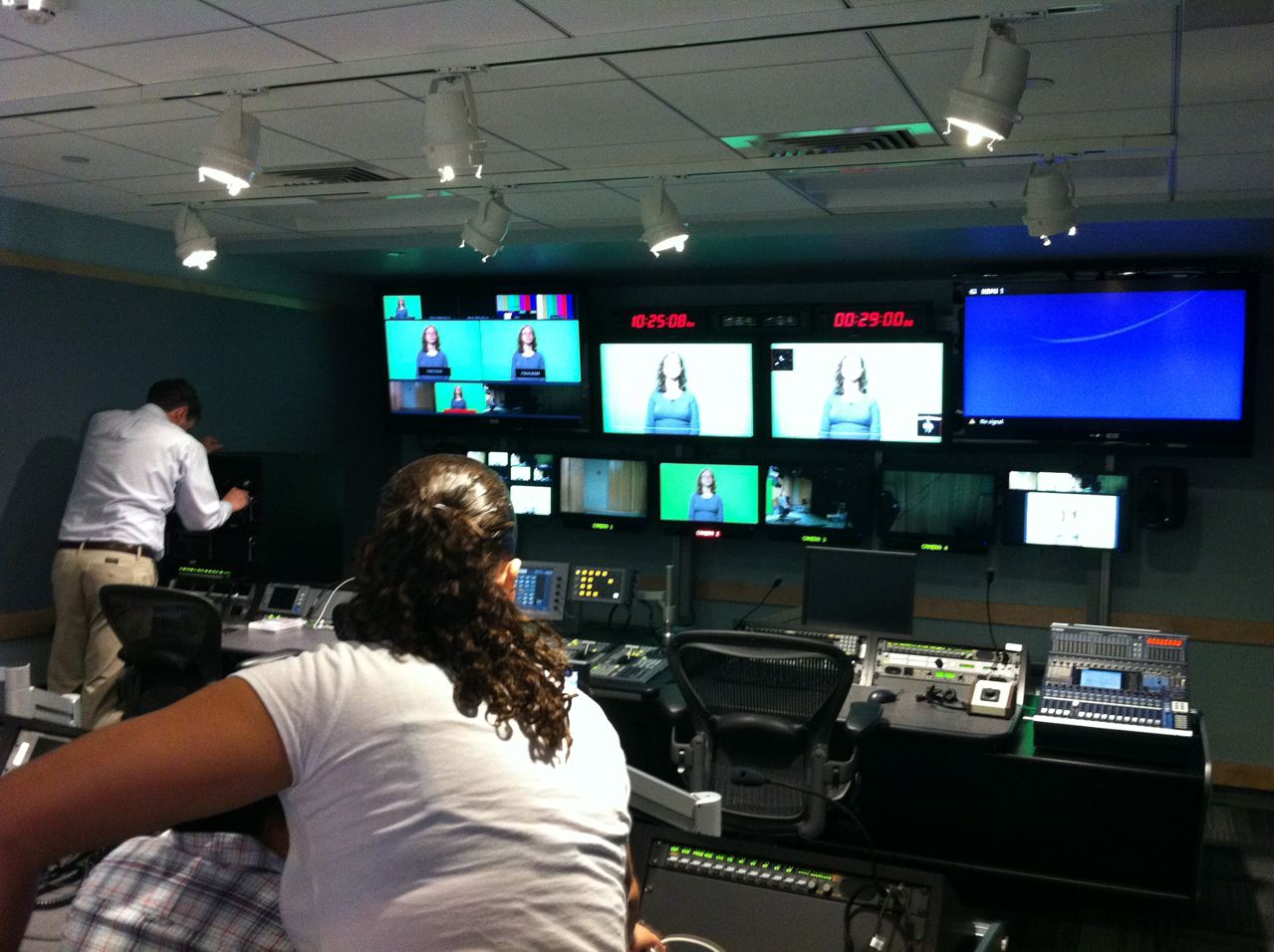 Multiple monitors in the production control room, all displaying what's on the various cameras in the studio