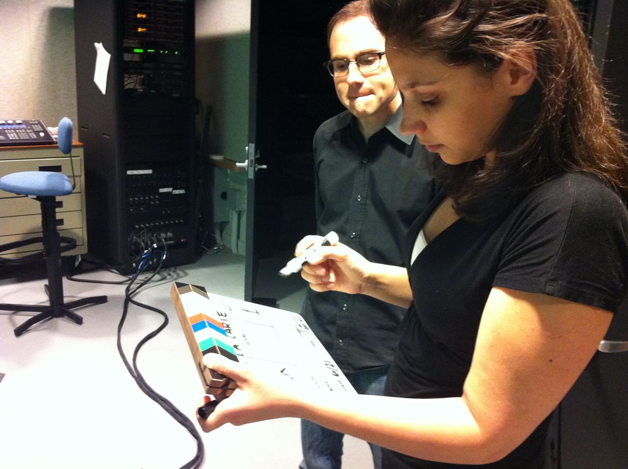 Robert Farrell (Coordinator of Information Literacy & Assessment) and Allie Verbovetskaya (Instructional Technologies Librarian) writing scene/take information on a clapperboard